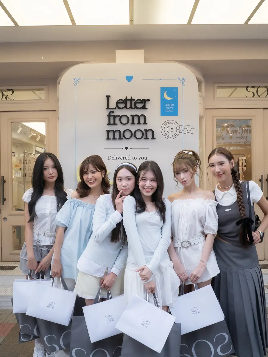 SOS 시암스퀘어점 입구의 Letter from moon 조형물 앞에 선 태국 인플루언서들 — 저마다 SOS 쇼핑백을 들고 있습니다